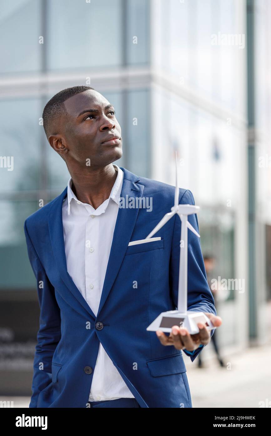 Thoughtful engineer holding wind turbine model Stock Photo