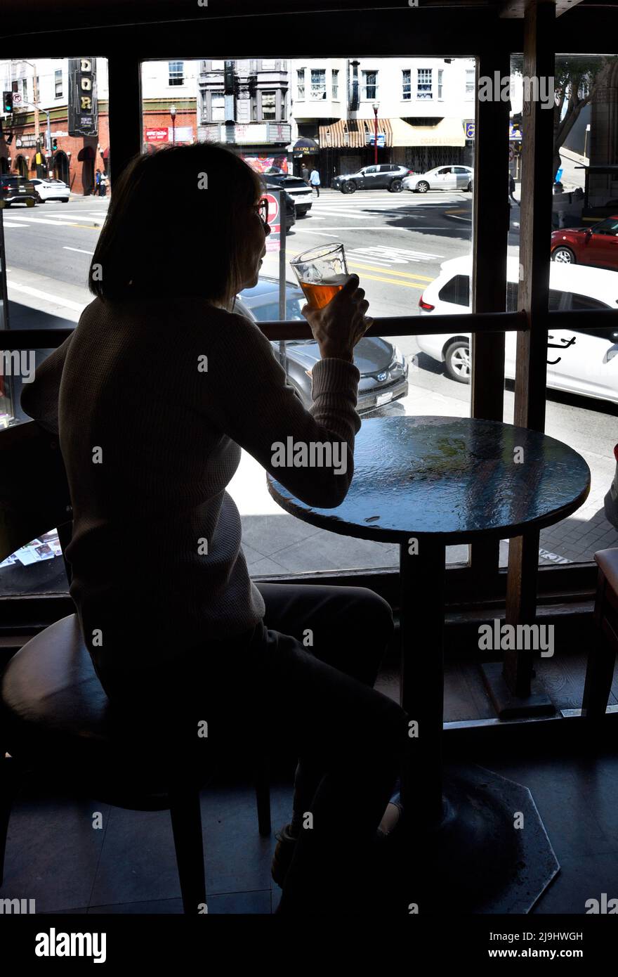 A woman enjoys a beer at the Vesuvio Cafe, a landmark American bar in the North Beach section of San Francisco, California. Stock Photo