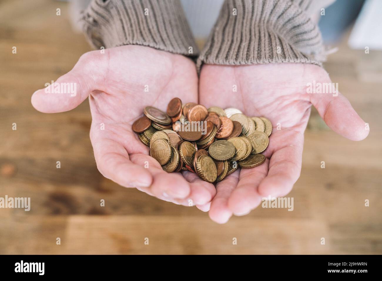 Close up of cupped hands with small change Stock Photo