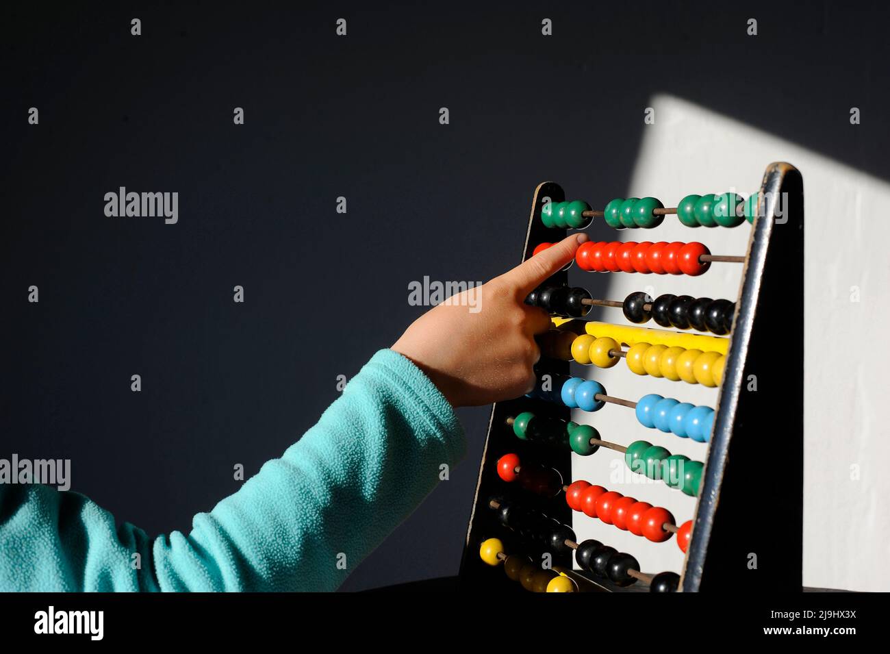 Boy calculating with colorful abacus at home Stock Photo