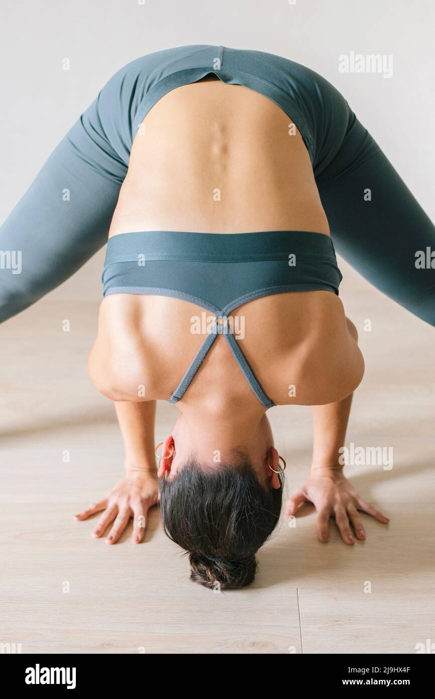 Woman practicing headstand at yoga studio Stock Photo