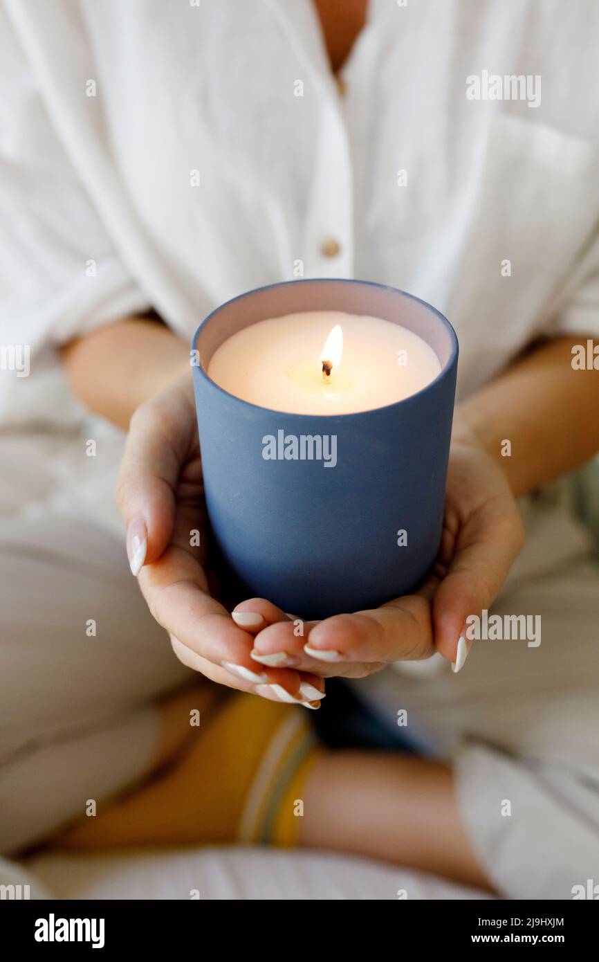 Hands of woman holding scented candle at home Stock Photo