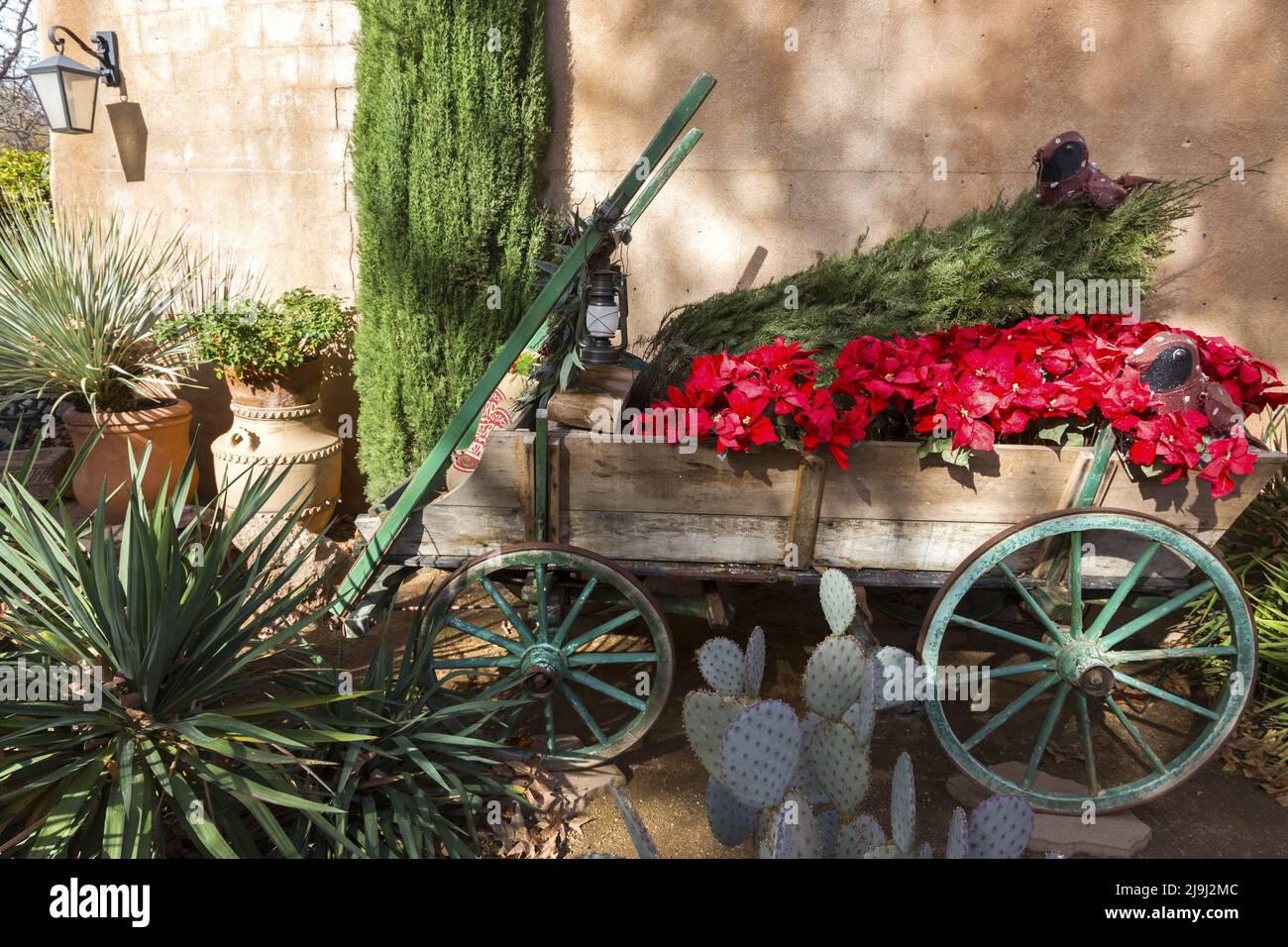 Vintage Horsedrawn Wooden Horse Cart with Red Flowers and Green Cactus Plant Detail in Tlaquepaque Spanish Arts and Crafts Village, Sedona Arizona USA Stock Photo