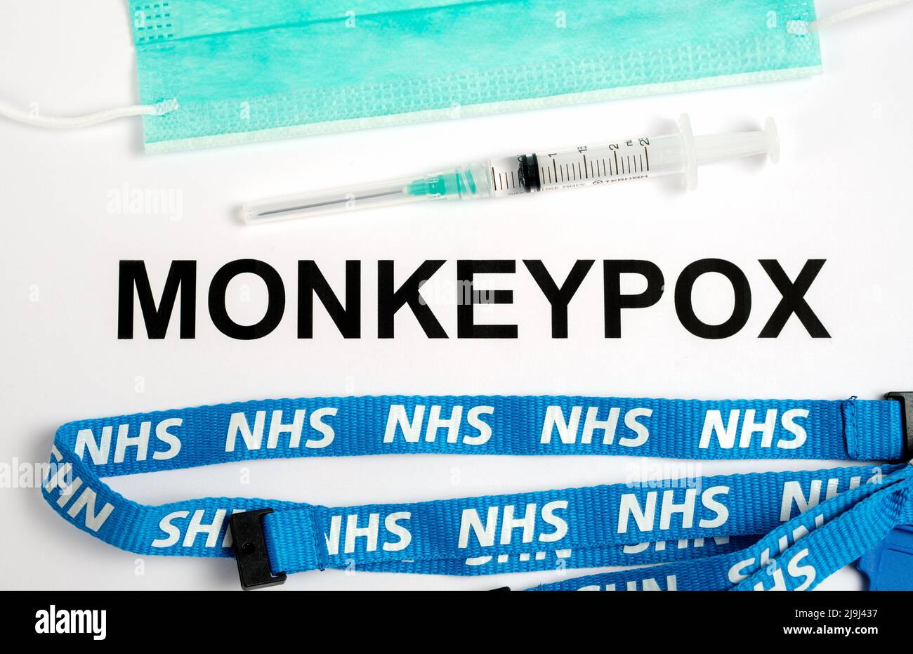 MONKEYPOX infection name seen printed on paper with syringe and NHS lanyard next to it. Concept. Stafford, United Kingdom, May 23, 2022. Stock Photo