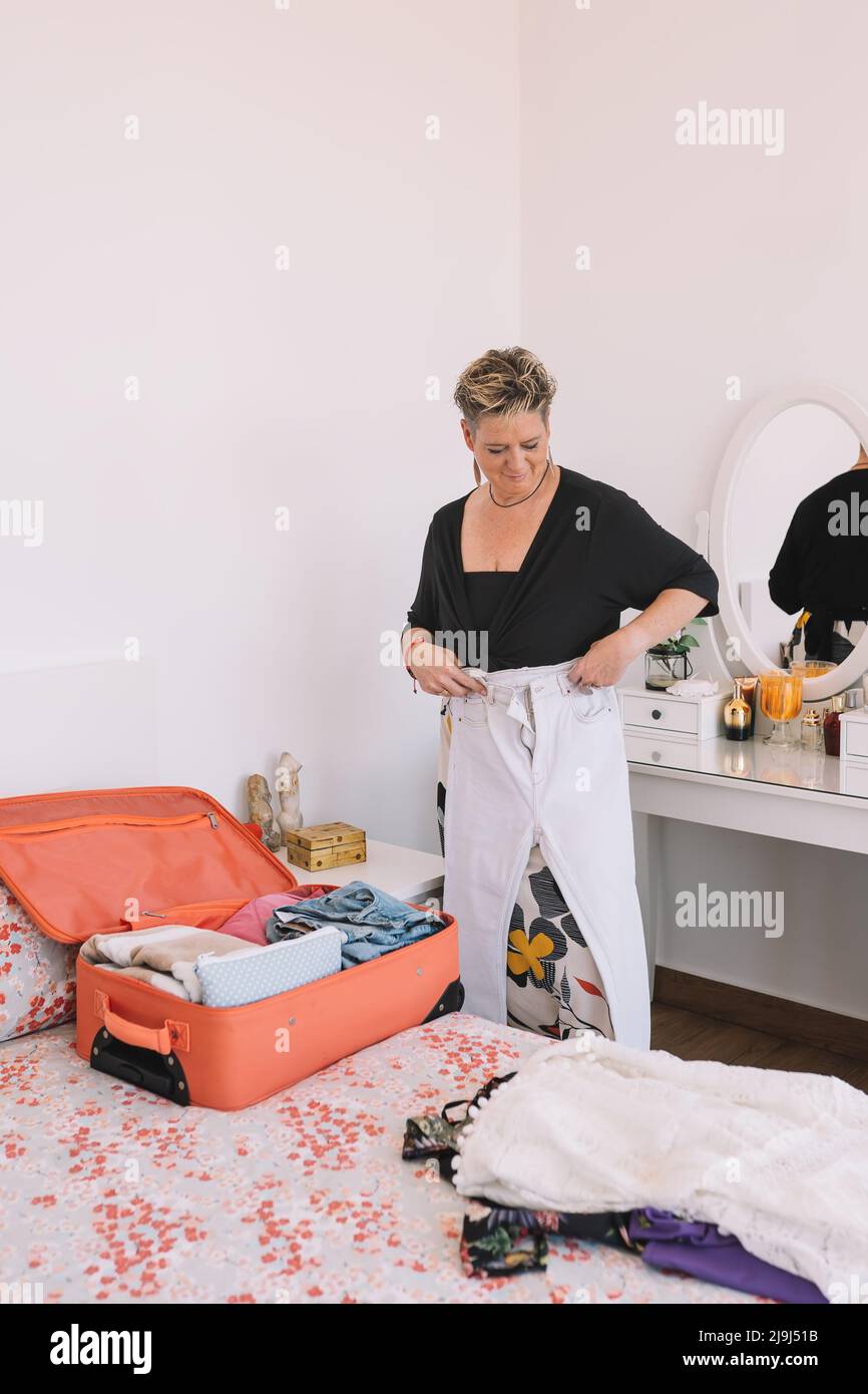 business woman folding clothes to prepare her luggage. tourist woman preparing her suitcase for business trip. Stock Photo