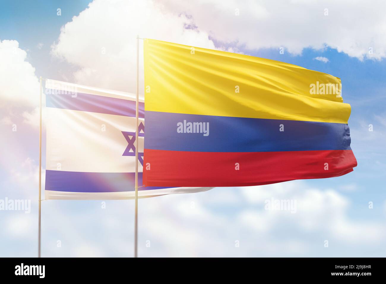 Sunny blue sky and flags of colombia and israel Stock Photo