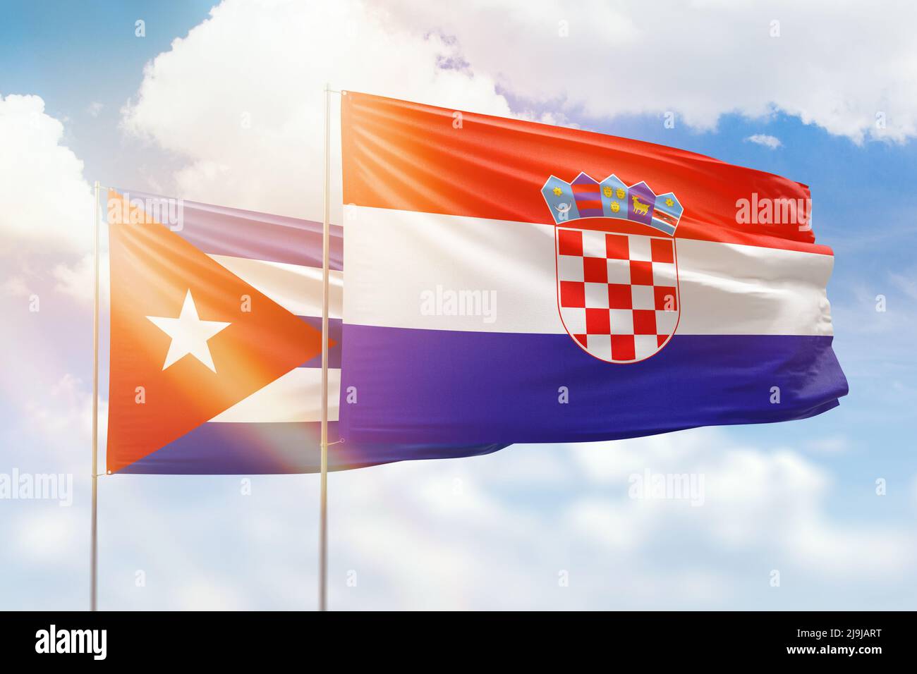 Sunny blue sky and flags of croatia and cuba Stock Photo