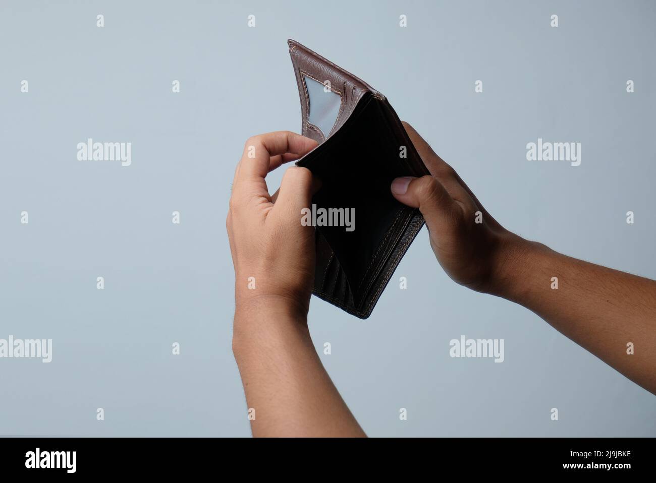 hand holding empty wallet isolated in white background Stock Photo