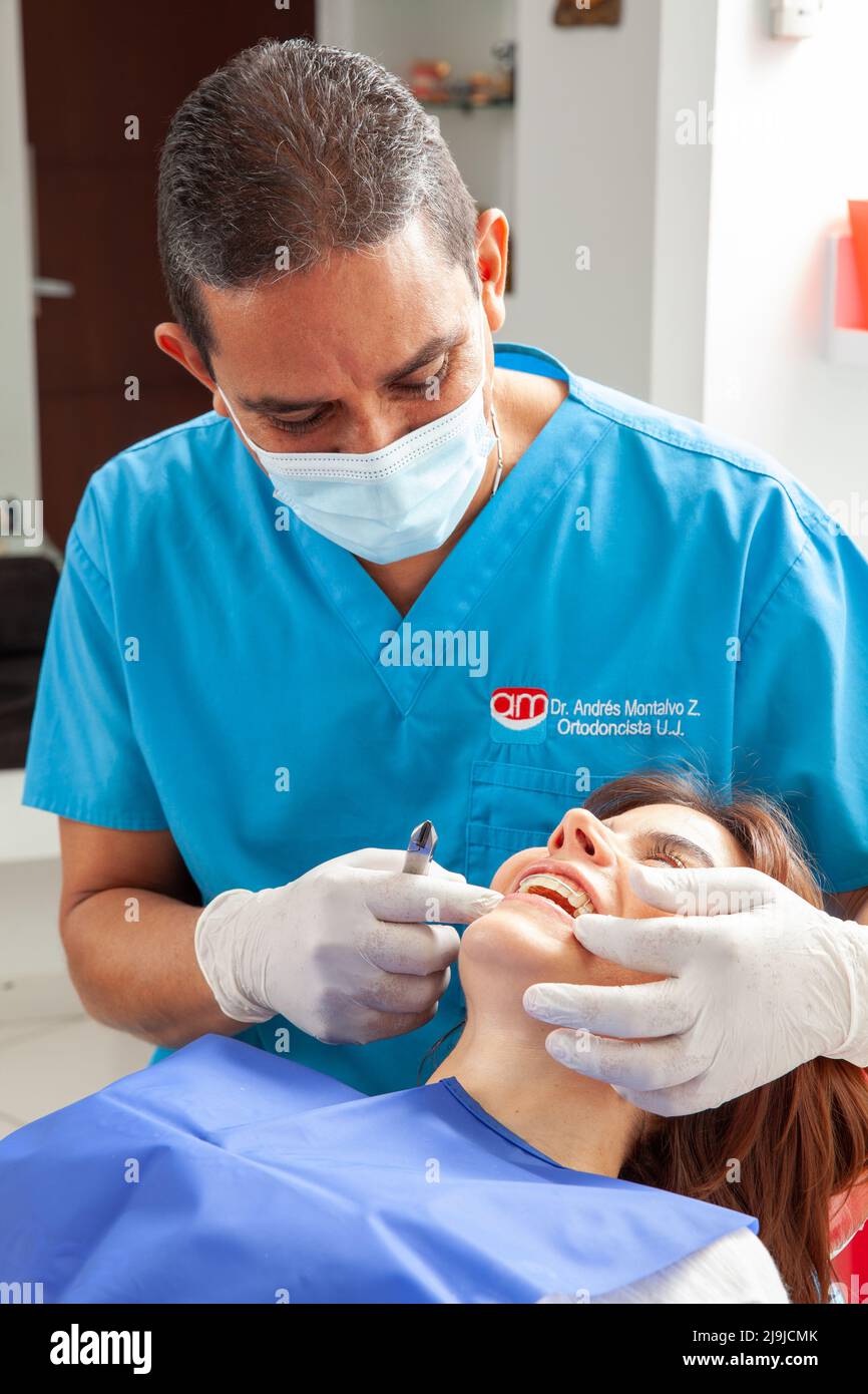 Orthodontic specialist dentist treating an adult female patient Stock