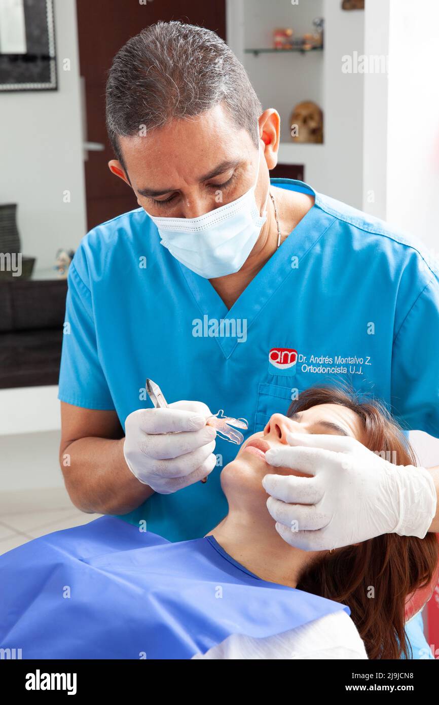 Orthodontic specialist dentist treating an adult female patient Stock