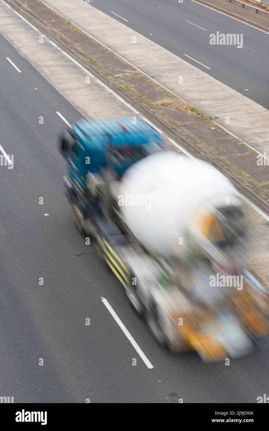 A blurred image from above and behind of a concrete mixer truck (no brand names) speeding on a motorway in Sydney, Australia Stock Photo