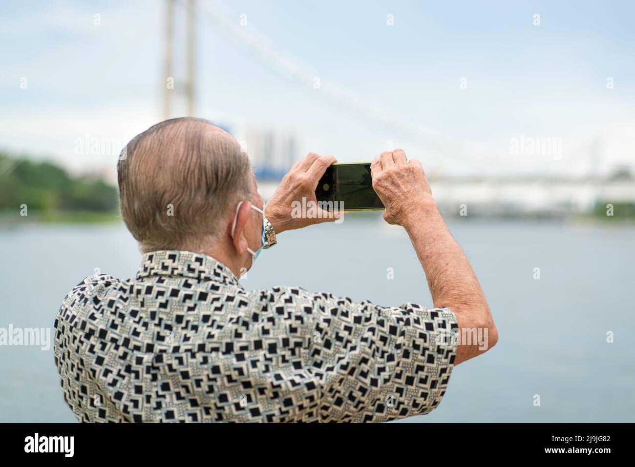 Senior man using smartphone to take photos and video. Travel and technology lifestyle for seniors. Stock Photo