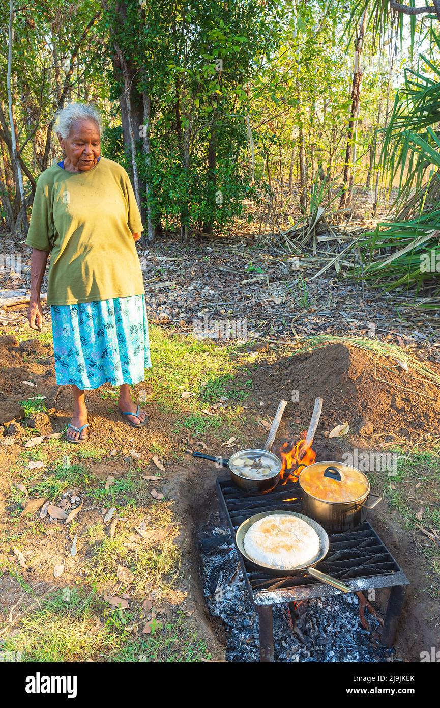 Old Aboriginal woman cooking on a fire during the Taste of Kakadu Festival, Cooinda, Kakadu National Park, Northern Territory, NT, Australia Stock Photo