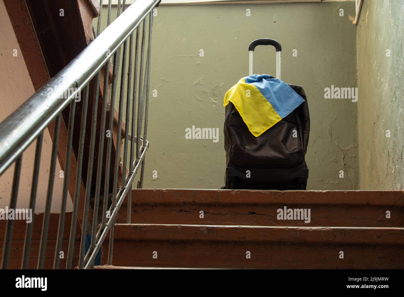 A suitcase with the flag of Ukraine stands in the entrance of the house, people leave their homes because of the war, Ukrainian refugees, the war in U Stock Photo