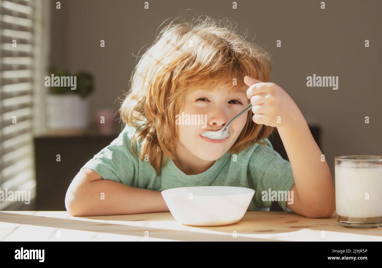 Child eat. Little healthy hungry boy eating soup from with spoon. Stock Photo