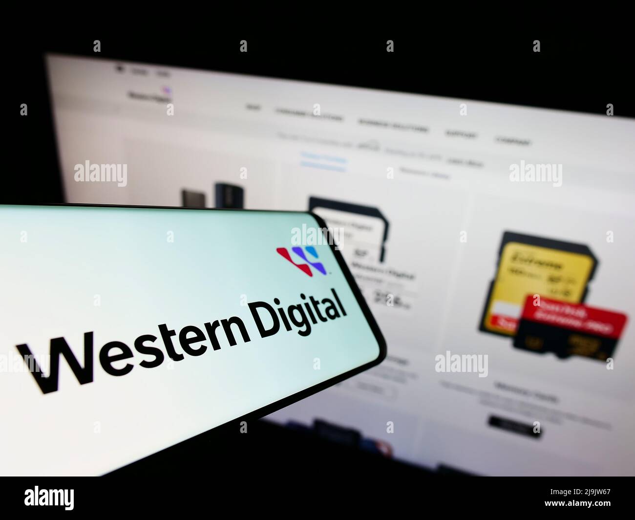 Mobile phone with logo of US company Western Digital Corporation (WDC) on screen in front of website. Focus on center-right of phone display. Stock Photo