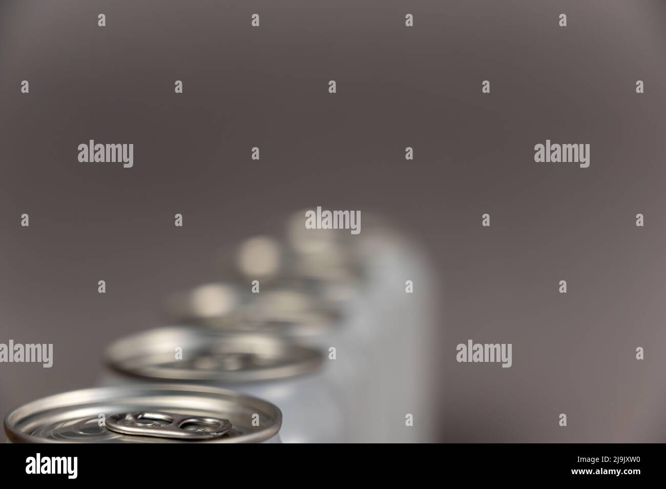 A defocused shot of a line of tin cans. New enclosed Metallic silver