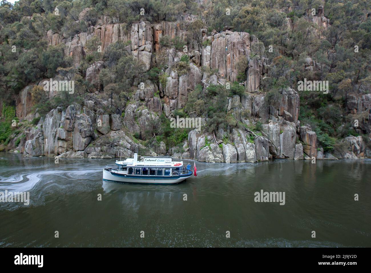 A cruise boat moves along the South Esk River in the lower section of the Cataract Gorge at Launceston in Tasmania, Australia. Stock Photo