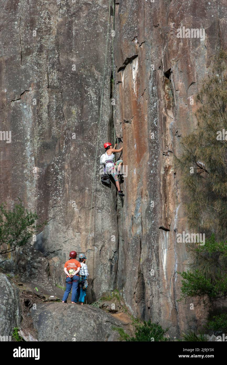 A rock climber begins to ascend a granite cliff face on the lower section of the Cataract Gorge at Launceston in Tasmania, Australia. Stock Photo