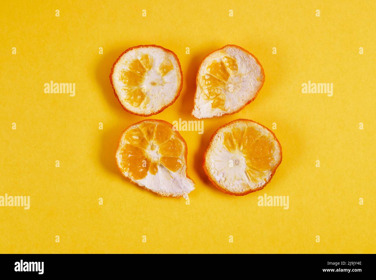 Several pieces of orange pell on yellow background Stock Photo