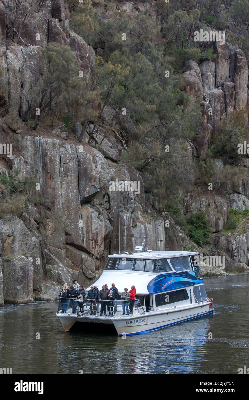 A catamaran cruise boat moves along the South Esk River in the lower section of the Cataract Gorge at Launceston in Tasmania, Australia. Stock Photo