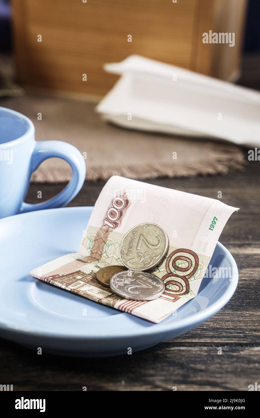 Restaurant tips or gratuity, russian banknotes and coins on plate Stock Photo