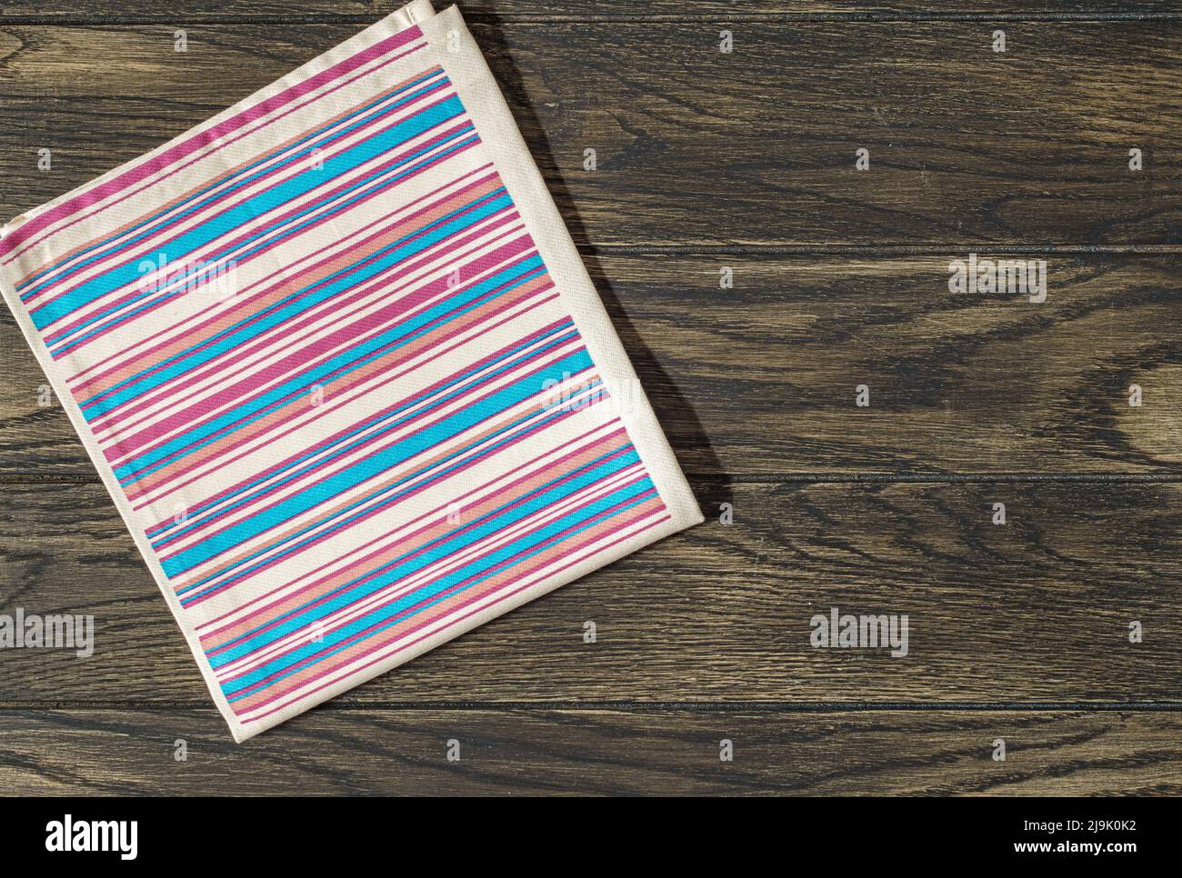 Striped napkin from left side of wooden table top view. Food background Stock Photo
