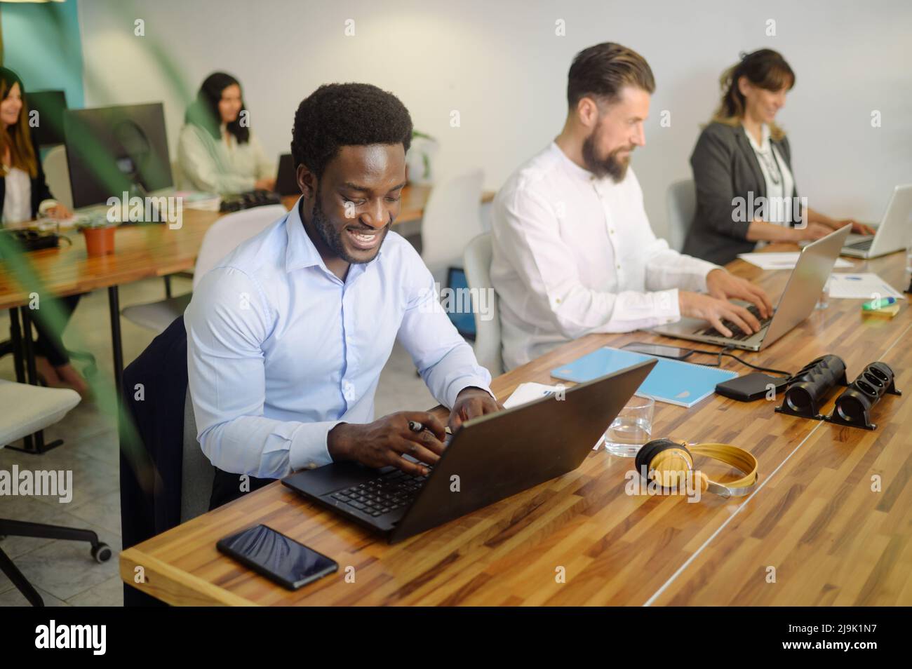 Diverse businesspeople working on laptops in office Stock Photo