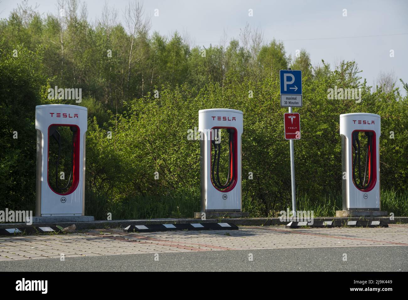 Tesla Superchargers against a backdrop of green trees Stock Photo Alamy