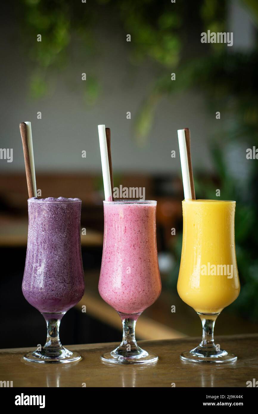organic mixed fresh fruit smoothie glasses on cafe table by day Stock Photo