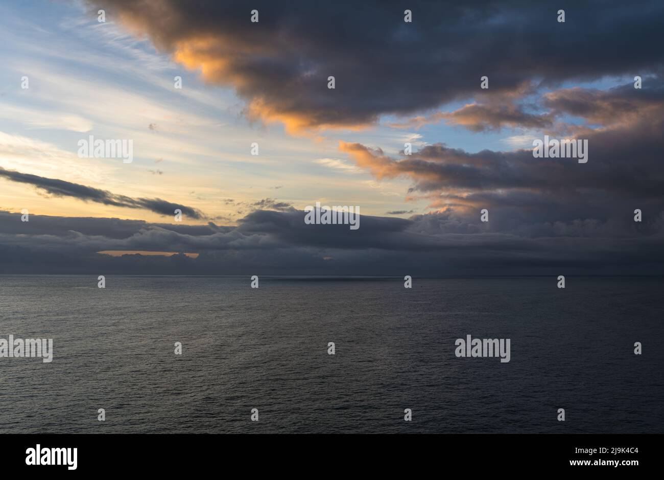 Dramatic sky over the sea at sunrise Stock Photo