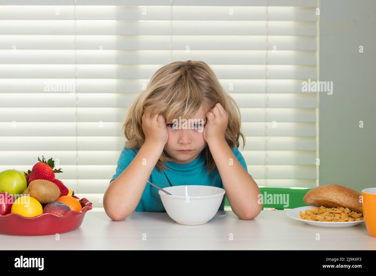 Portrait of child with no appetite. Concept of loss of appetite. Healthy nutrition for children. Cute boy enjoy eating for morning breakfast with Stock Photo