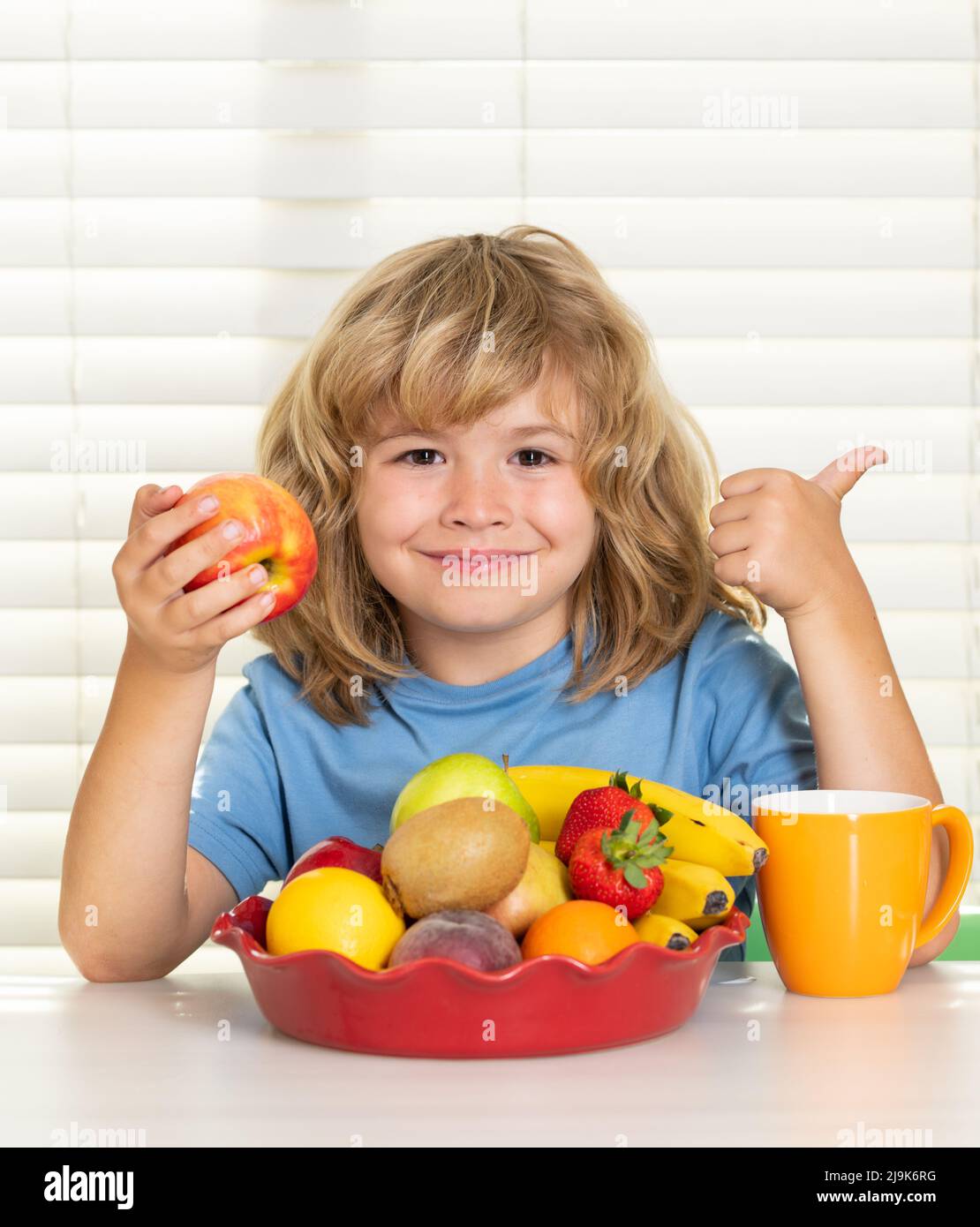 Kid eating apple. Portrait of child eat fresh healthy food in kitchen