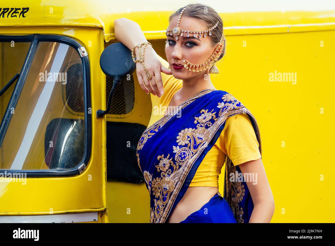 portrait indian beautiful Caucasian woman in traditional blue dress.hindu model with golden kundan jewelry set bindi earrings and nose ring piercing Stock Photo