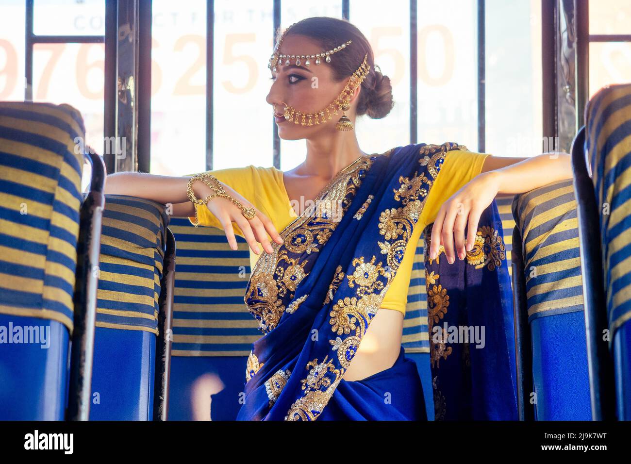portrait indian beautiful Caucasian woman in traditional blue dress.hindu model with golden kundan jewelry set bindi earrings and nose ring piercing Stock Photo