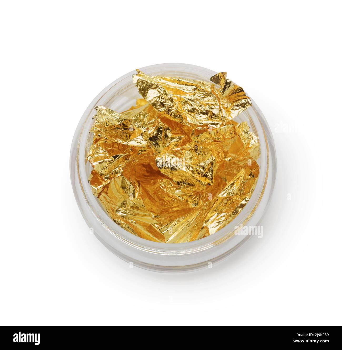 Top view of edible gold leaf flakes in glass jar isolated on white Stock Photo