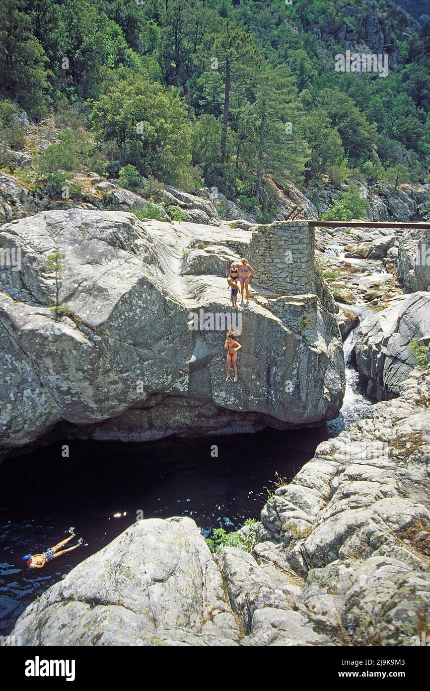 Cliff jumper jumping in a pool of a stream, water pool at Asco valley, Corsica, France, Mediterranean Sea, Europe Stock Photo