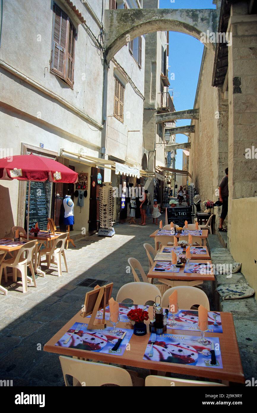 Restaurant and shops in a narrow alley, houses with arches in the historic old town of Bonifacio, Corse-du-Sud, Corsica, France, Mediterranean Sea Stock Photo