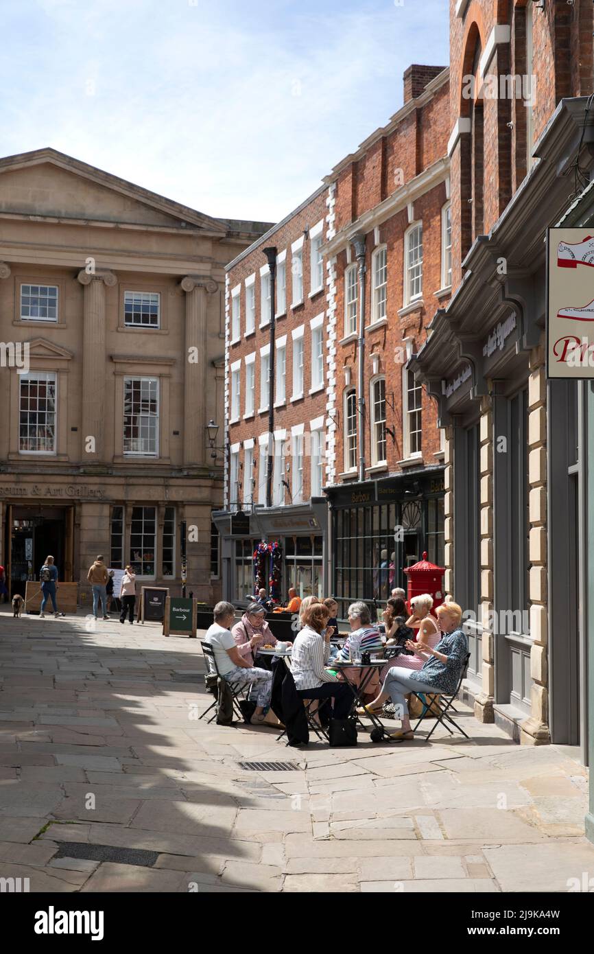 visitors sitting outside cafe in square, Shrewsbury, UK Stock Photo