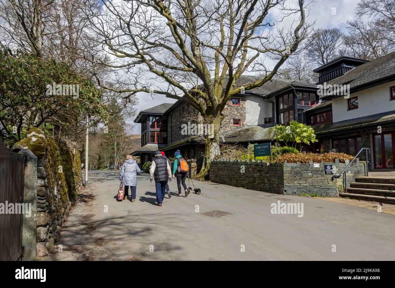 People tourists visitors walking by the Theatre by the Lake playhouse in spring Keswick Lake District Cumbria England UK United Kingdom Great Britain Stock Photo
