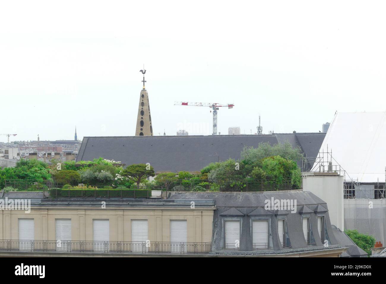 Paris, France. May 22. 2022. Parisian building terrace with vegetation. Crane construction in the background. Stock Photo