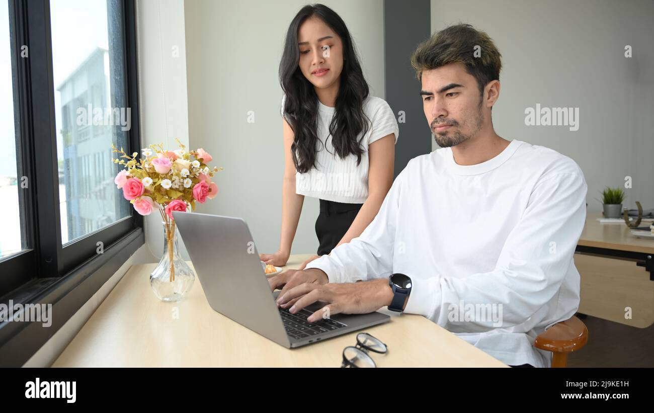 An Asian millennial man and woman collaborate on project campaign and ...