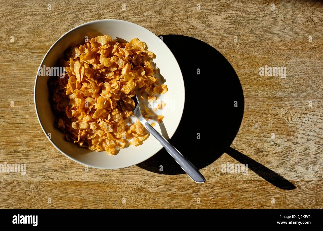 bowl of crunchy nut flakes on weathered table top Stock Photo