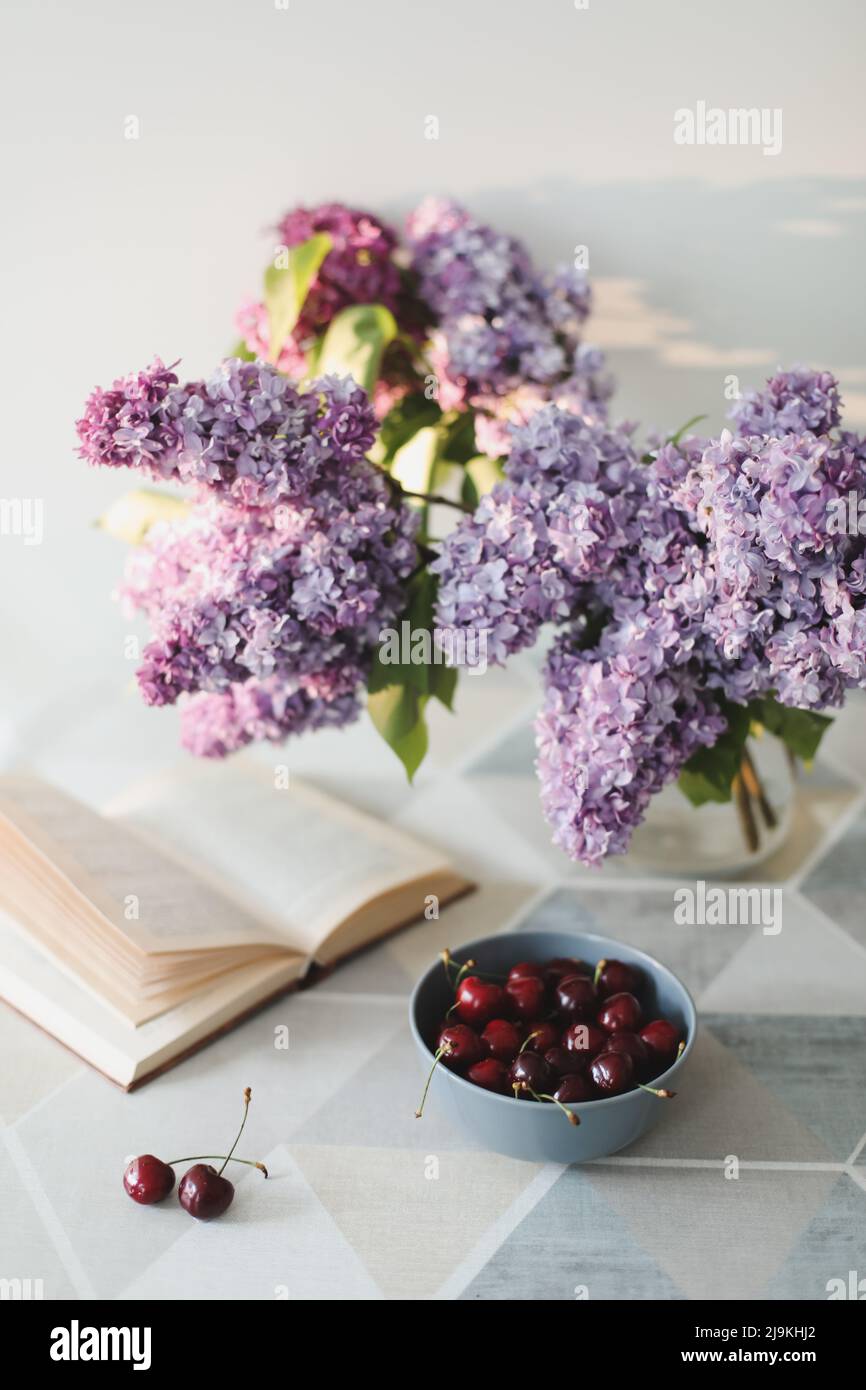 Still life lilac flowers in a vase on the table Stock Photo by