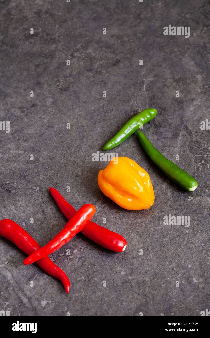 the word hot written out with chilies on mottled background Stock Photo