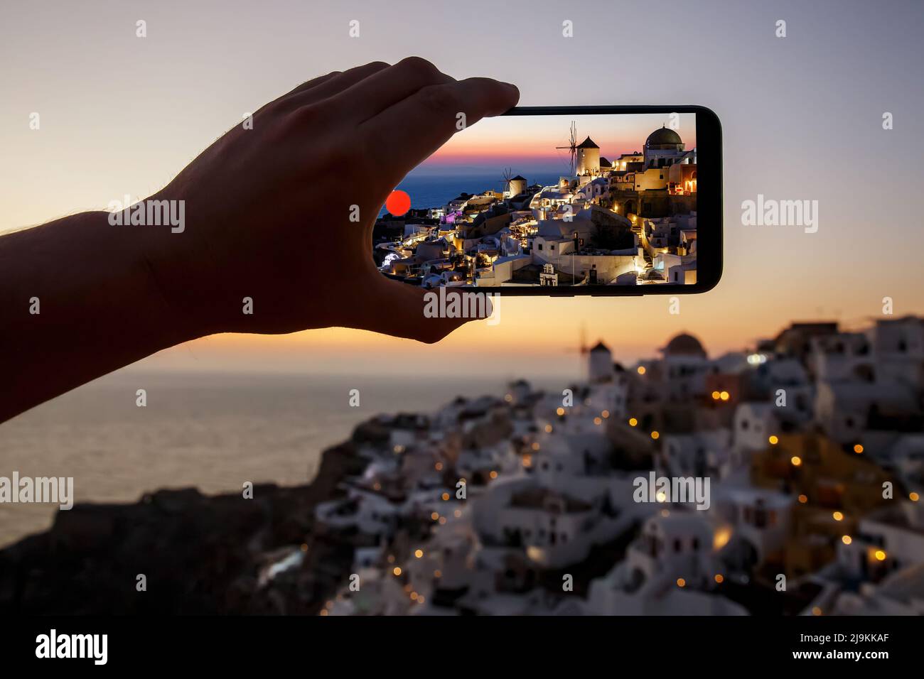 Tourist taking photo of the famous Santorini view using mobile phone