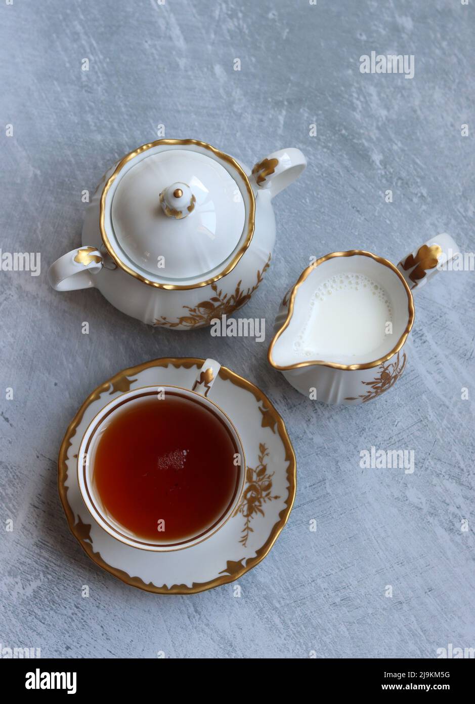 Tea with roses close up photo. Herbal tea in a small white ceramic cup on a table. Light grey background with copy space. Stock Photo