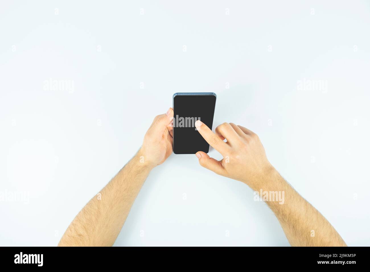 Man hands surfing on the net with a mobile phone, black screen, cellphone with copy space, clicking or touching on-screen, top view Stock Photo