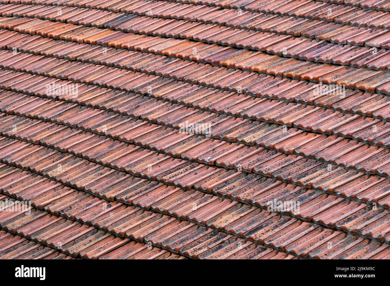 Weathered roof tile in dark orange color, old and dirty tiles, wide-angle Stock Photo