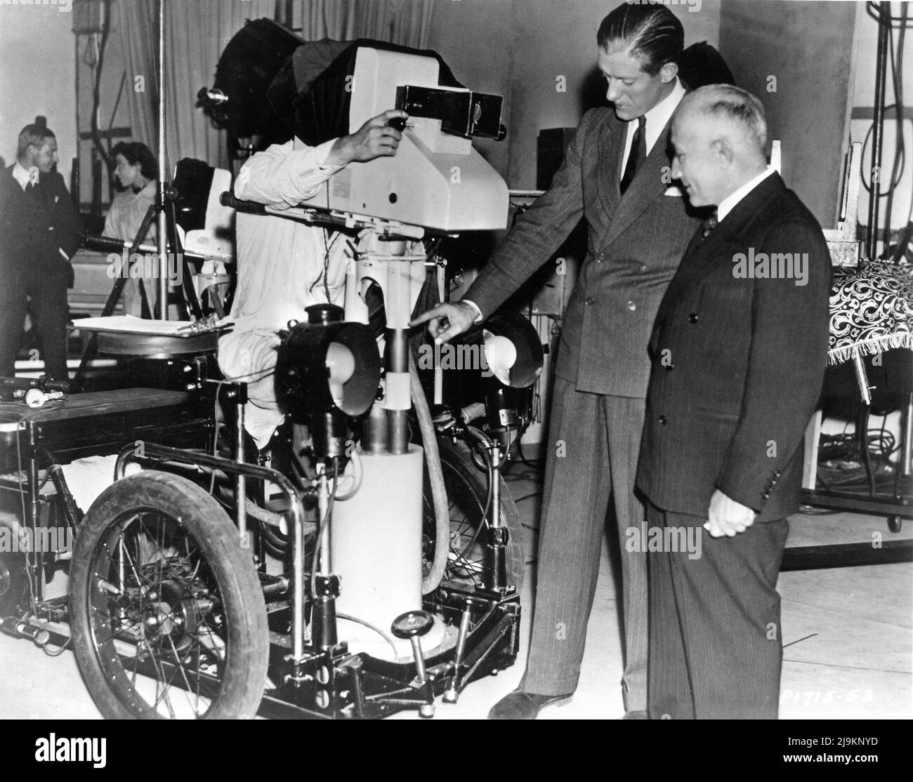 GERALD COOK shows Paramount Pictures Executive / Chairman of the Board ADOLPH ZUKOR the new EMITRON CAMERA at the BBC TELEVISION STATION / STUDIO / PLANT at ALEXANDRA PALACE in North London during his visit there in late 1937 publicity for Paramount Pictures Stock Photo